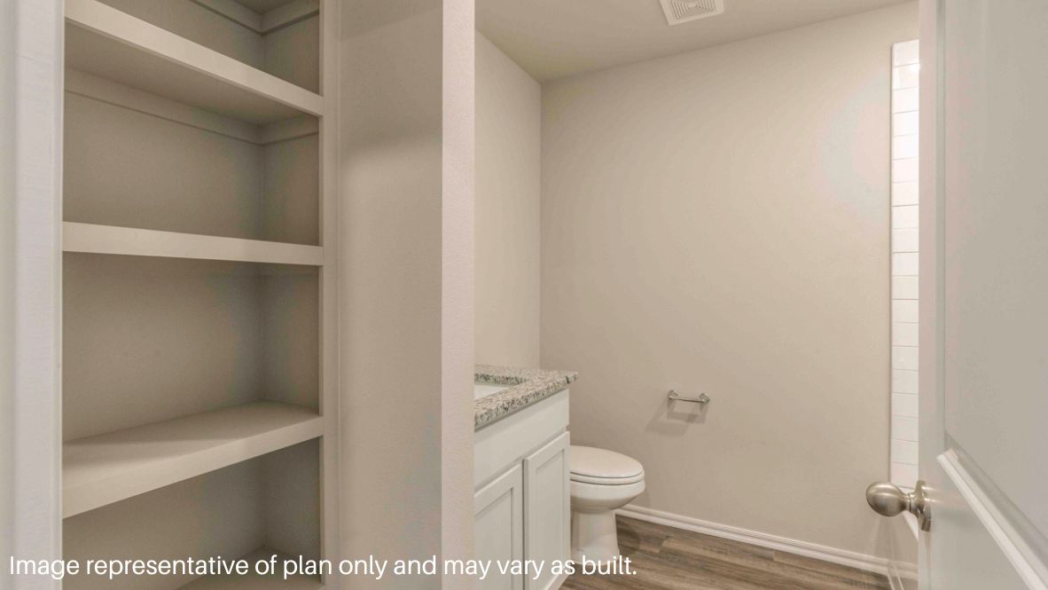 Primary bedroom with plush carpeting, and a large walk-in closet.