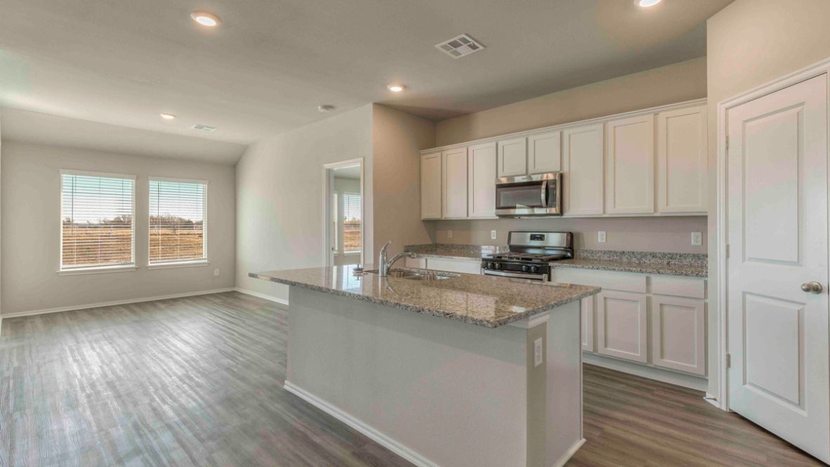 Bright and spacious kitchen with granite countertops, stainless steel appliances, and an island with bar seating