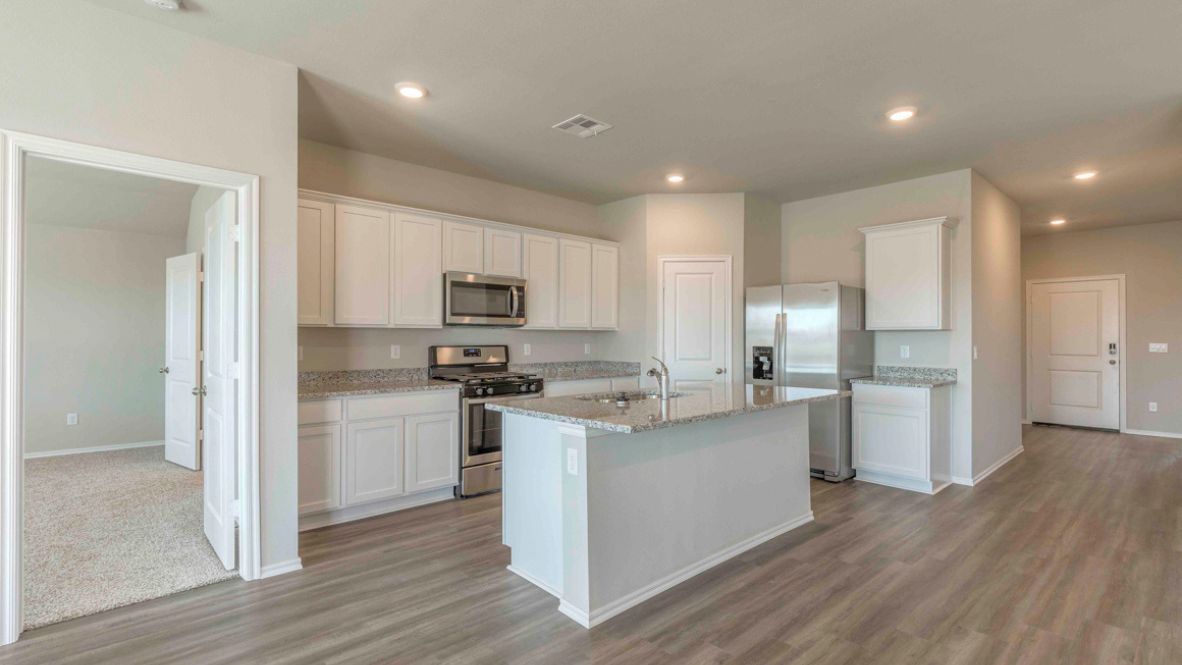 Bright and spacious kitchen with granite countertops, stainless steel appliances, and an island with bar seating