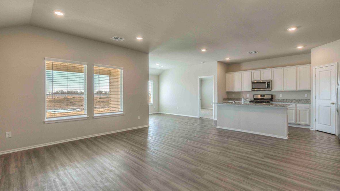 Bright and spacious kitchen with granite countertops, stainless steel appliances, and an island with bar seating