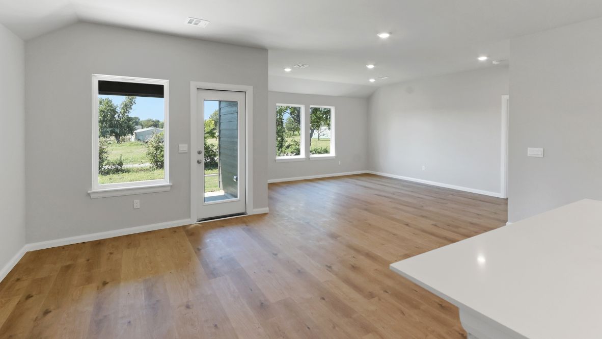 A well-organized living room that includes a kitchen and dining area, creating a warm and welcoming environment for gatherings.