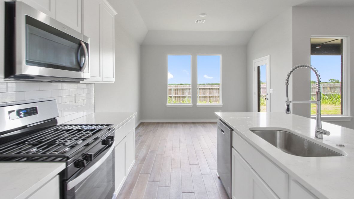 Formal dining room with large windows, vinyl wood floors, and view of the backyard.