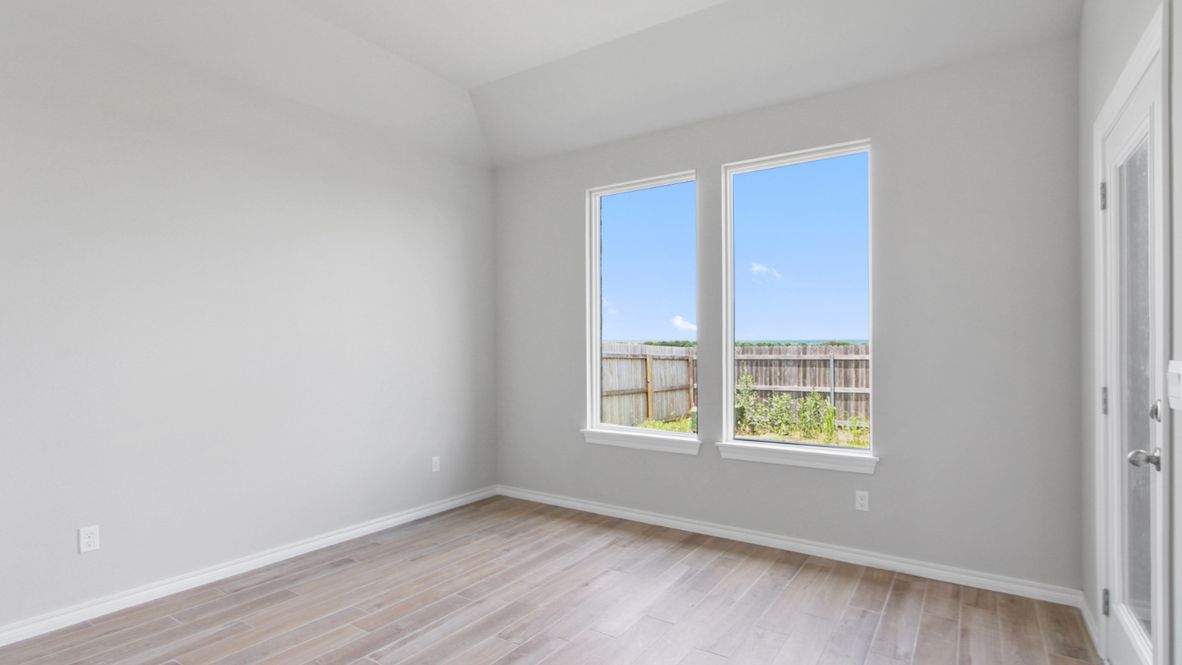 Primary bedroom with ceiling fan, plush carpeting, and a large walk-in closet.