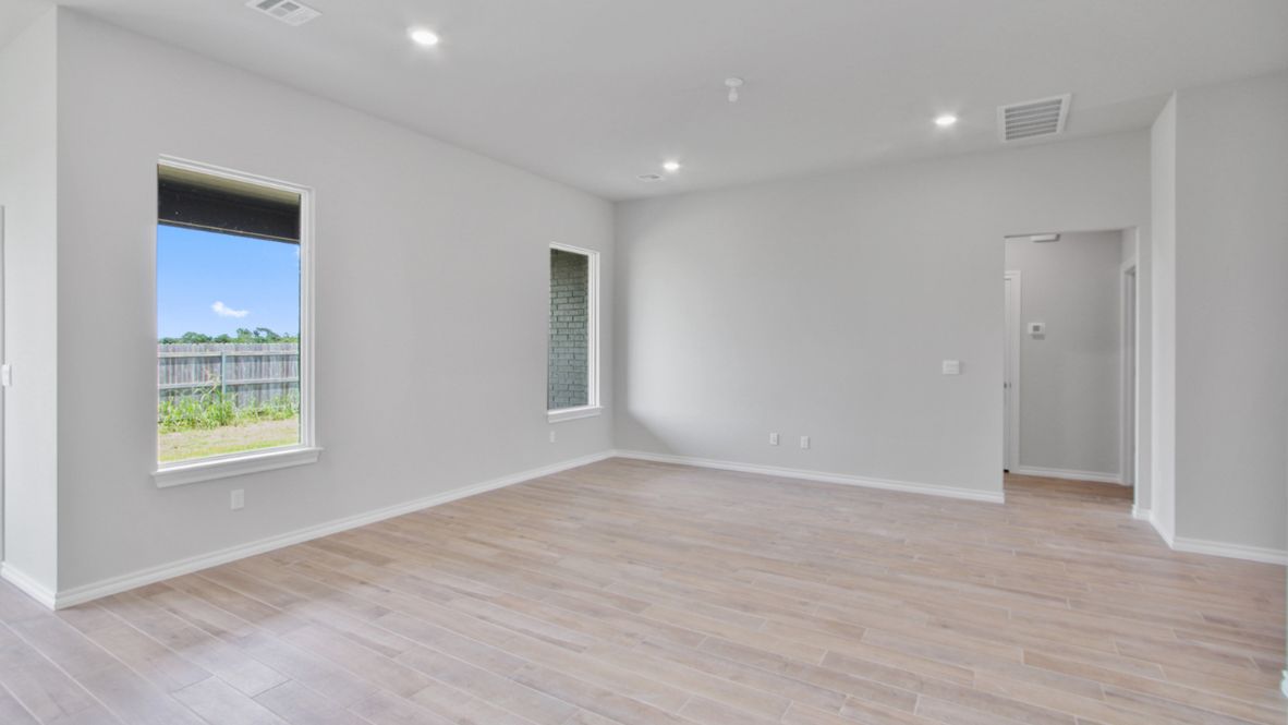 Primary bedroom with ceiling fan, plush carpeting, and a large walk-in closet.