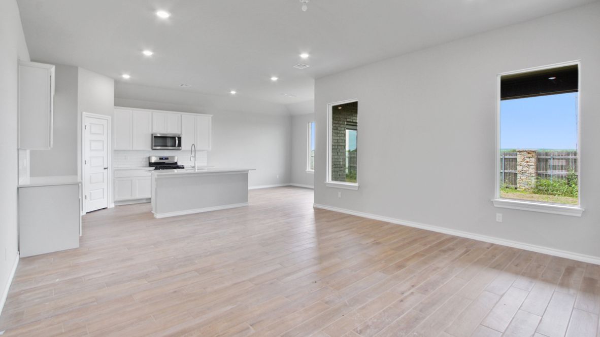 A well-organized living room that includes a kitchen and dining area, creating a warm and welcoming environment for gatherings.