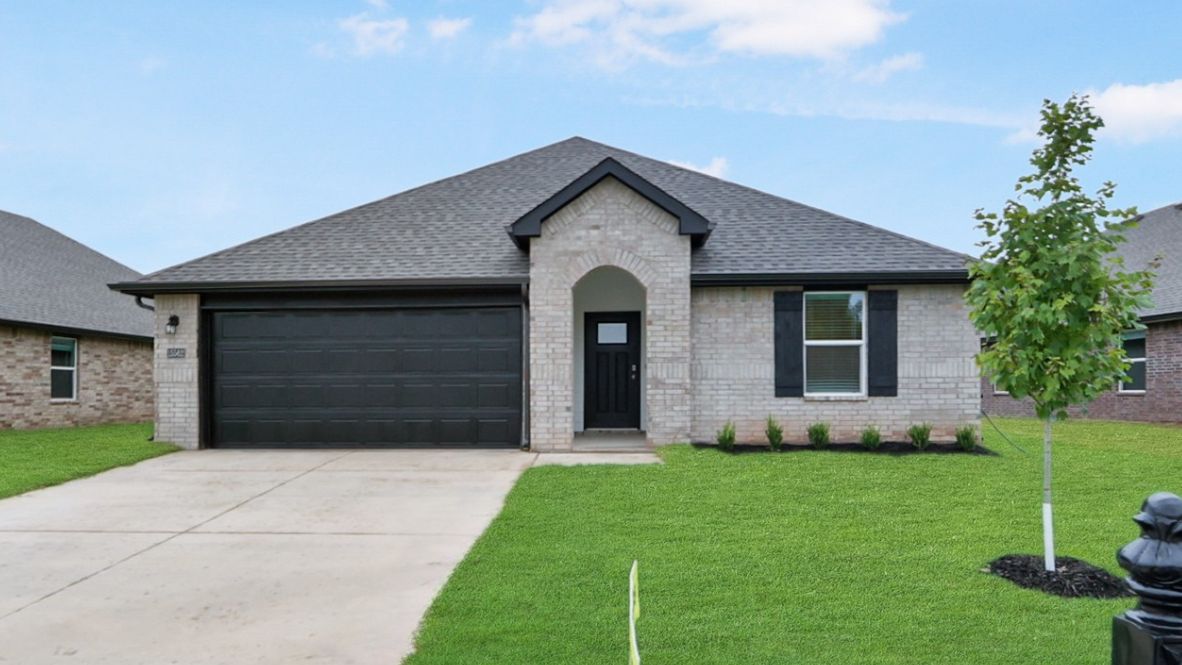 Driveway-level exterior view showing garage, entry, and front yard
