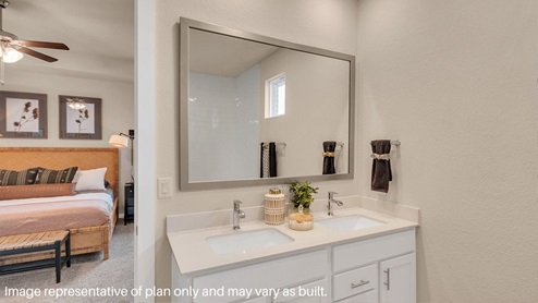 Modern primary bathroom with double vanities, granite countertops, and a glass-enclosed shower with a walk-in closet.