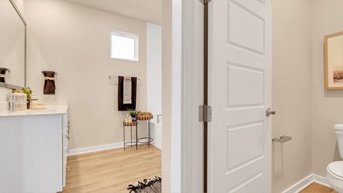 Modern primary bathroom with double vanities, granite countertops, and a glass-enclosed shower with a walk-in closet.