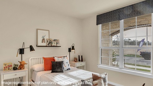 A vibrant kids' bedroom showcasing a neatly made bed, a stylish dresser, and a playful painting that adds charm.