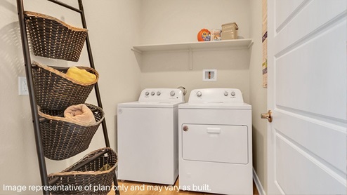 A laundry room featuring a washer and dryer, neatly arranged with ample space for laundry tasks and storage.