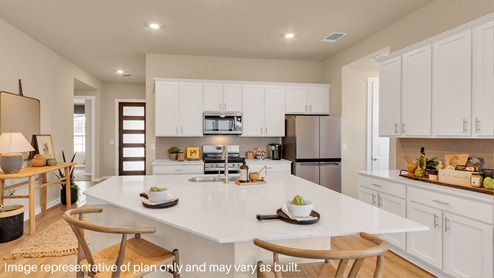 Bright and spacious kitchen with granite countertops, stainless steel appliances, and an island with bar seating.