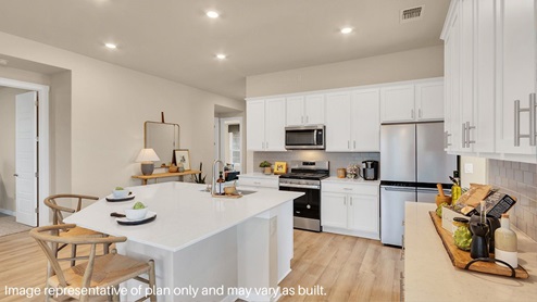 Bright and spacious kitchen with granite countertops, stainless steel appliances, and an island with bar seating.