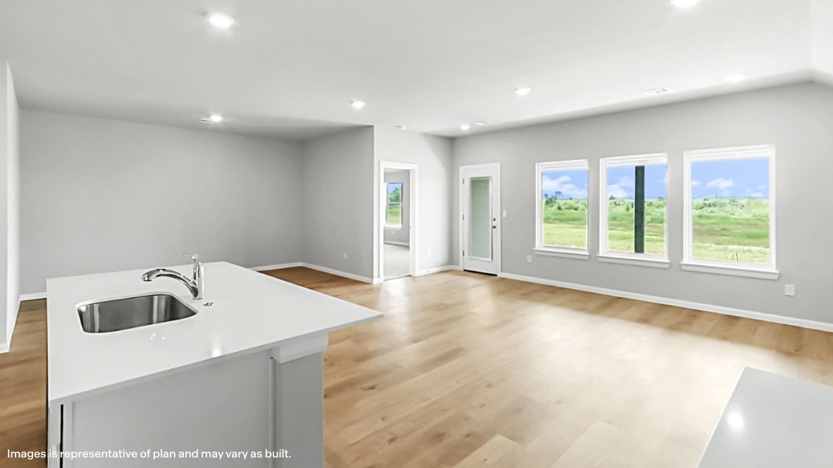 Contemporary kitchen adorned with white cabinets seamlessly integrated into an open dining area layout.