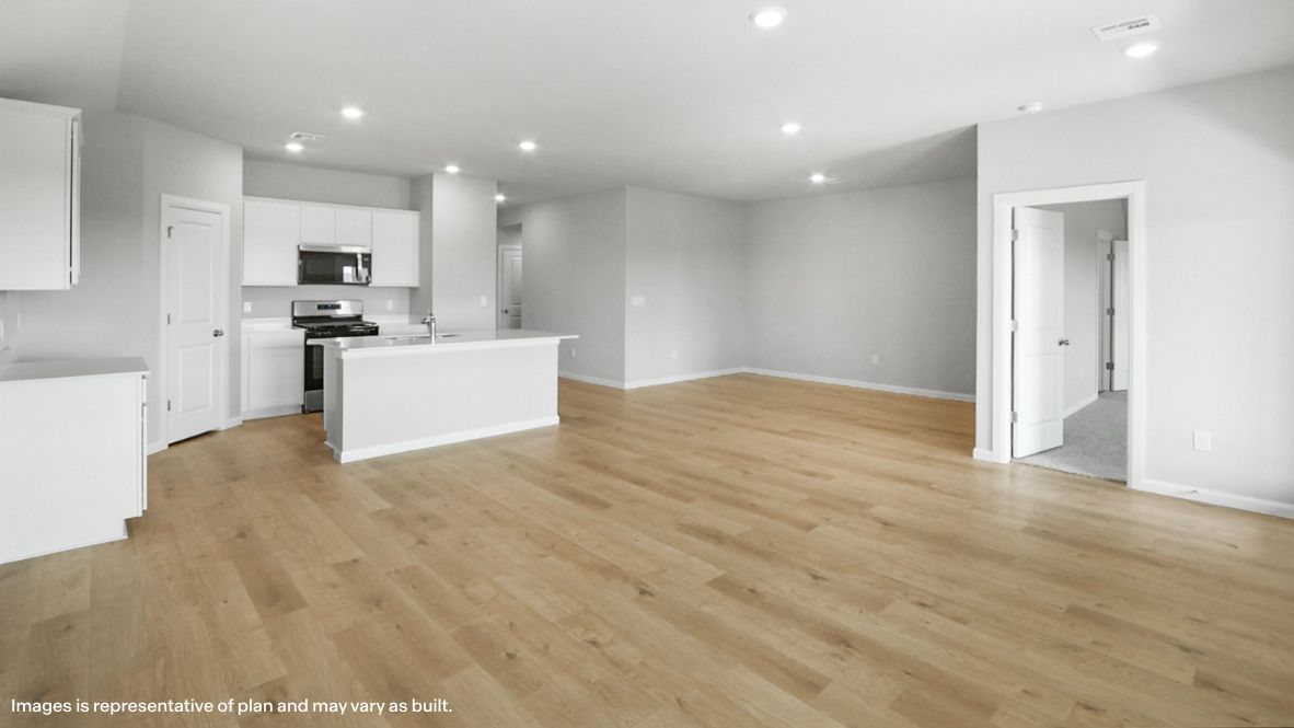 Looking from living room to dining, kitchen and primary bedroom entrance Justin plan