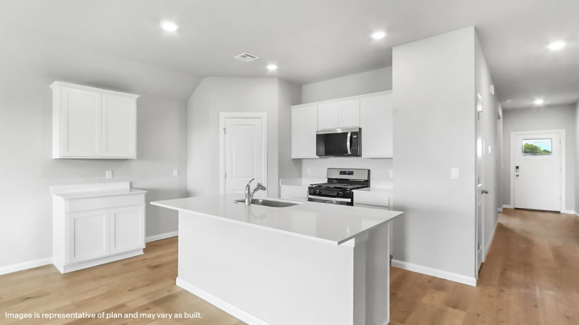 Kitchen island with new appliance suite included and sightline toward the front door