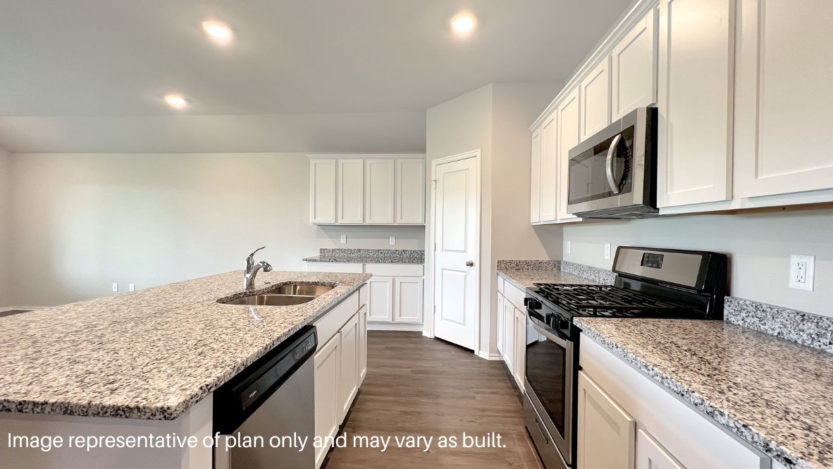 Bright and spacious kitchen with quartz countertops, stainless steel appliances, and an island with bar seating.