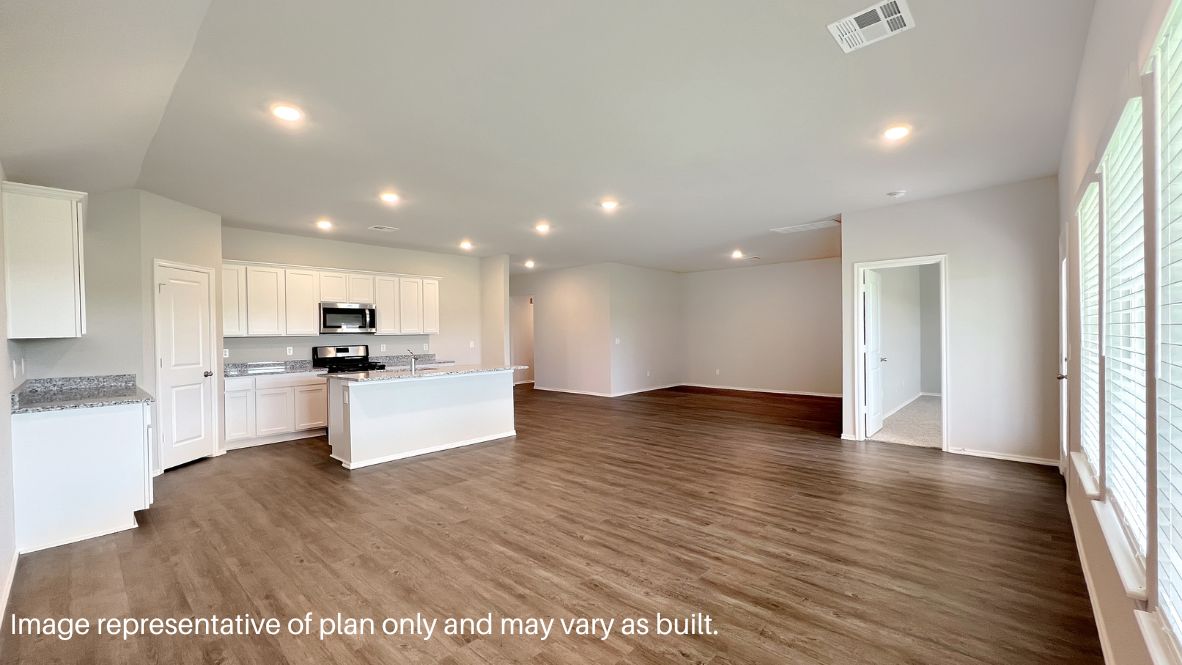 A well-organized living room that includes a kitchen and dining area, creating a warm and welcoming environment for gatherings.
