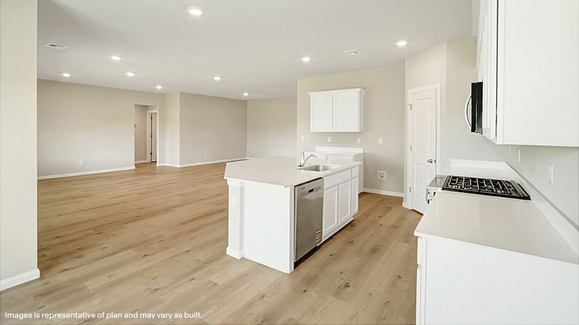 Bright and spacious kitchen with quartz countertops, stainless steel appliances, and an island with bar seating.