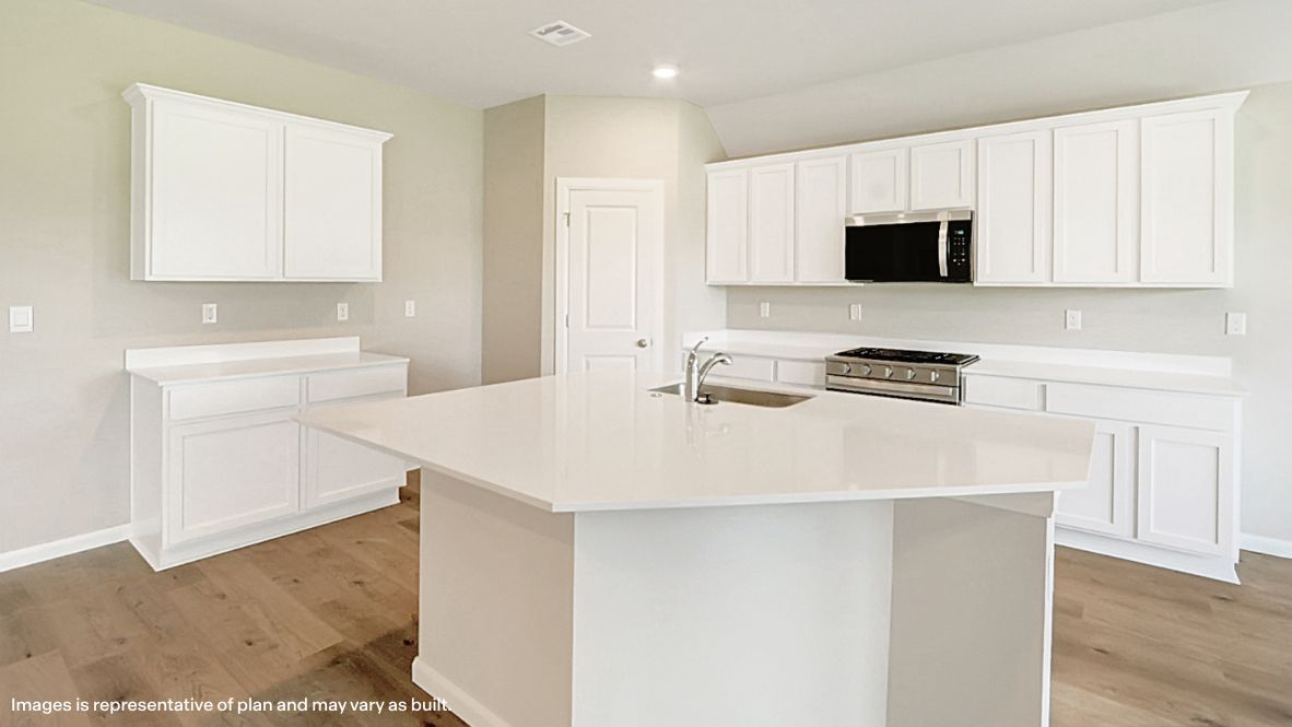 Bright and spacious kitchen with quartz countertops, stainless steel appliances, and an island with bar seating.