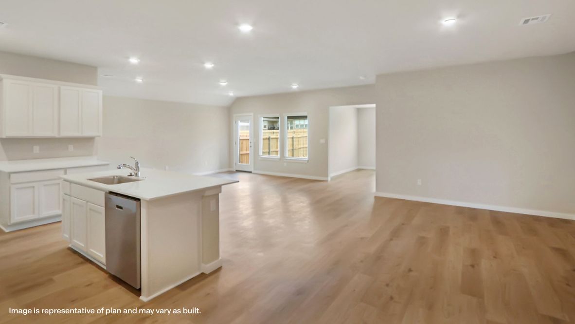 A cozy living room feature vinyl wood flooring and a view to the kitchen and dining area.