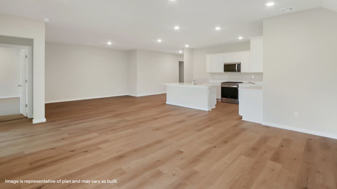 A cozy living room feature vinyl wood flooring and a view to the kitchen and dining area.