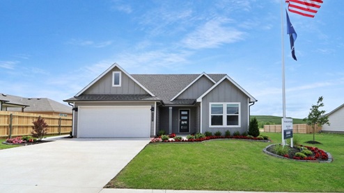Exterior of one story home with two car garage and wood cladding