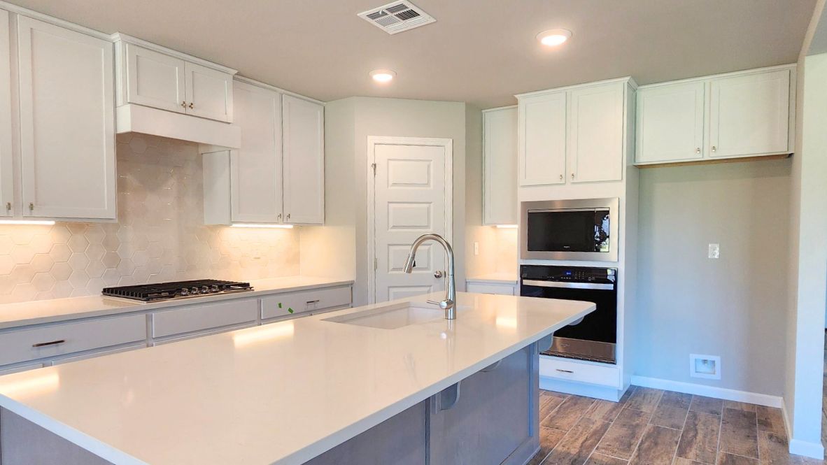 Contemporary kitchen adorned with white cabinets seamlessly integrated into an open dining area layout.