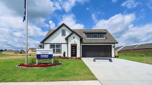 Exterior of one story home with two car garage and wood cladding