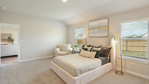 Interior of bedroom with two large windows and private bathroom