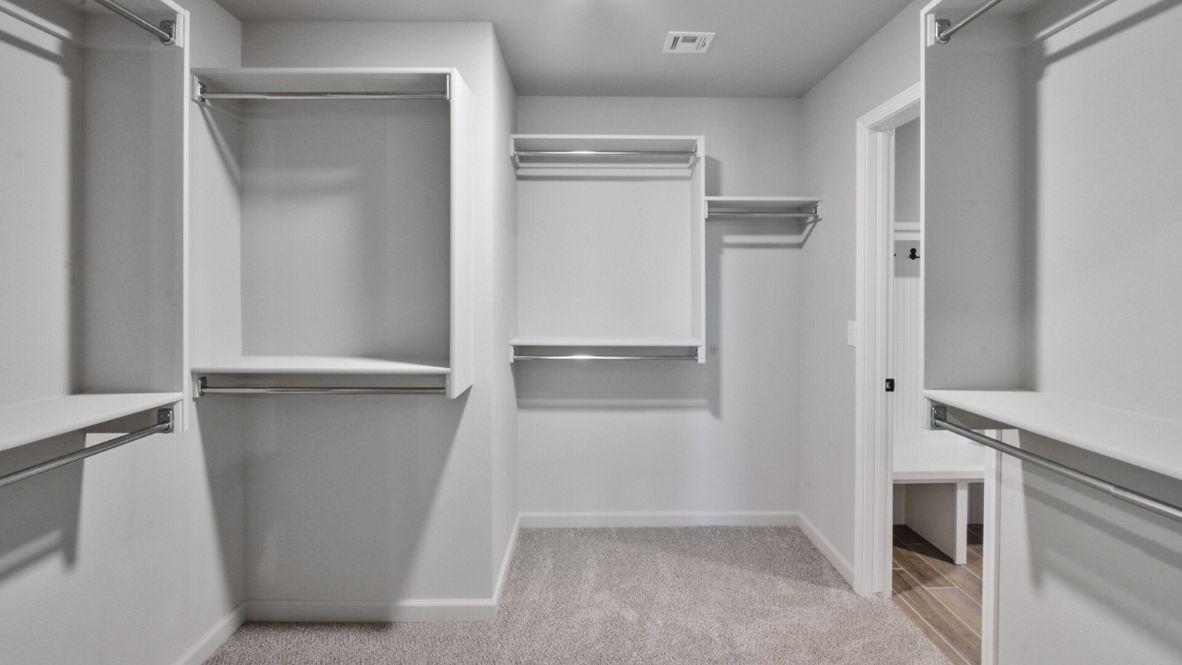 A laundry room featuring a washer and dryer, neatly arranged with ample space for laundry tasks and storage.