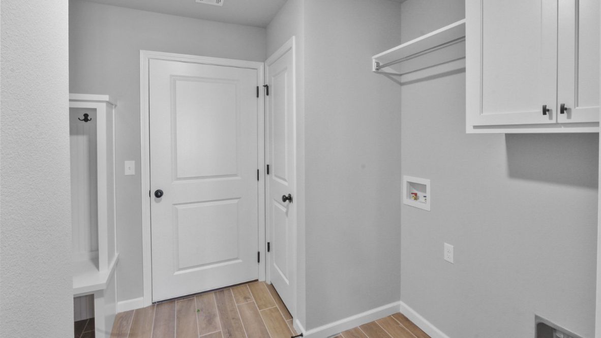 A laundry room featuring a washer and dryer, neatly arranged with ample space for laundry tasks and storage.