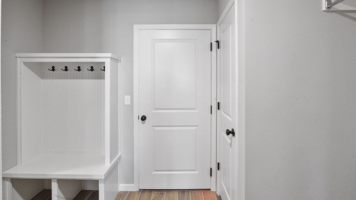 A laundry room featuring a washer and dryer, neatly arranged with ample space for laundry tasks and storage.