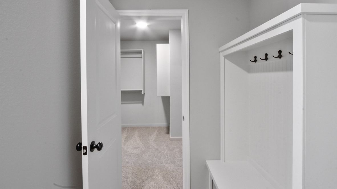 A laundry room featuring a washer and dryer, neatly arranged with ample space for laundry tasks and storage.