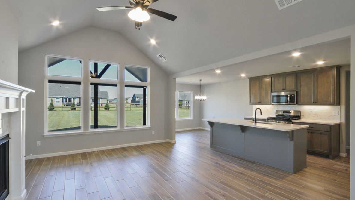Bright and spacious kitchen with granite countertops, stainless steel appliances, and an island with bar seating.