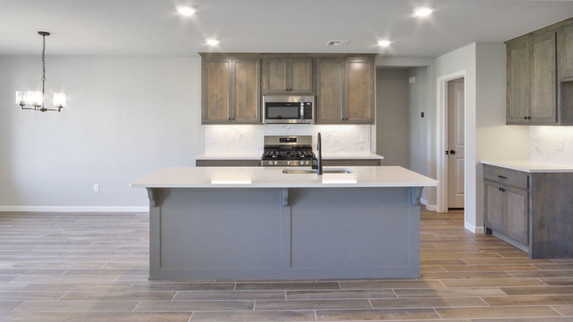 Bright and spacious kitchen with granite countertops, stainless steel appliances, and an island with bar seating.