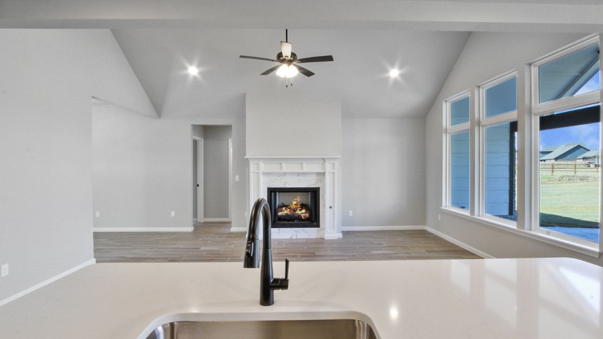 Bright and spacious kitchen with granite countertops, stainless steel appliances, and an island with bar seating.