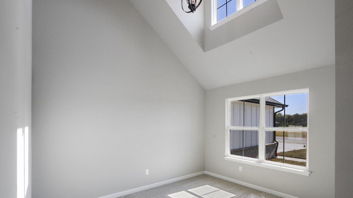 Spacious dining area with vinyl wood flooring, large window and tall ceiling.