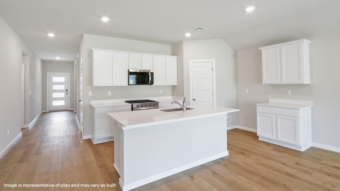 Bright and spacious kitchen with quartz countertops, stainless steel appliances, and an island with bar seating.
