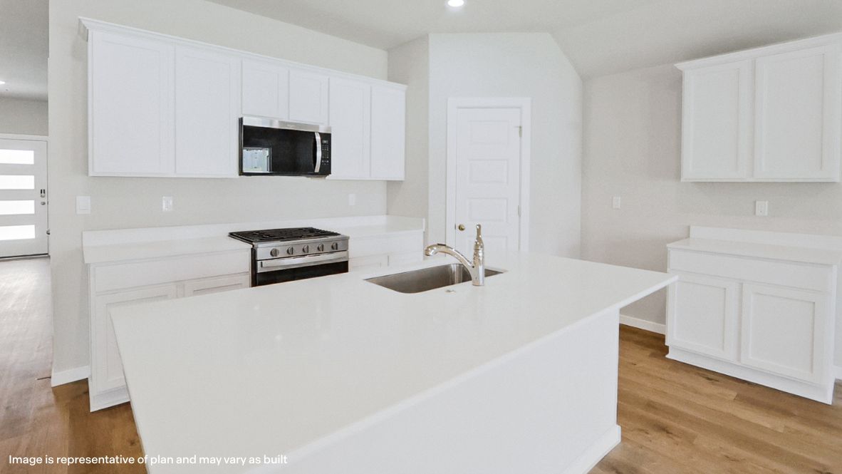 Bright and spacious kitchen with quartz countertops, stainless steel appliances, and an island with bar seating.