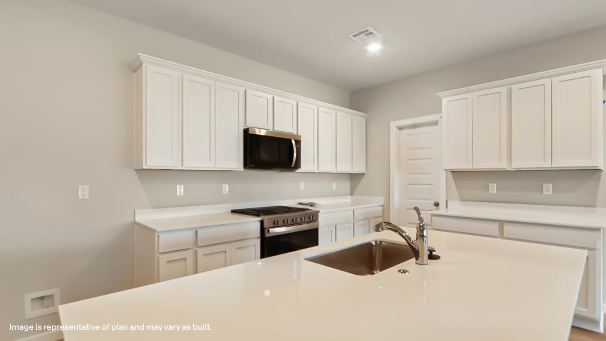 Bright and spacious kitchen with quartz countertops, stainless steel appliances, and an island with bar seating.