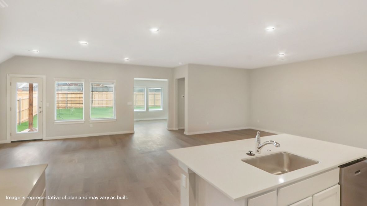 Bright and spacious kitchen with quartz countertops, stainless steel appliances, and an island with bar seating.