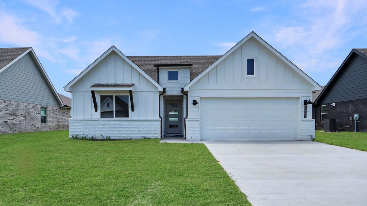 Wide street perspective showing driveway, entry walkway, and surrounding homes