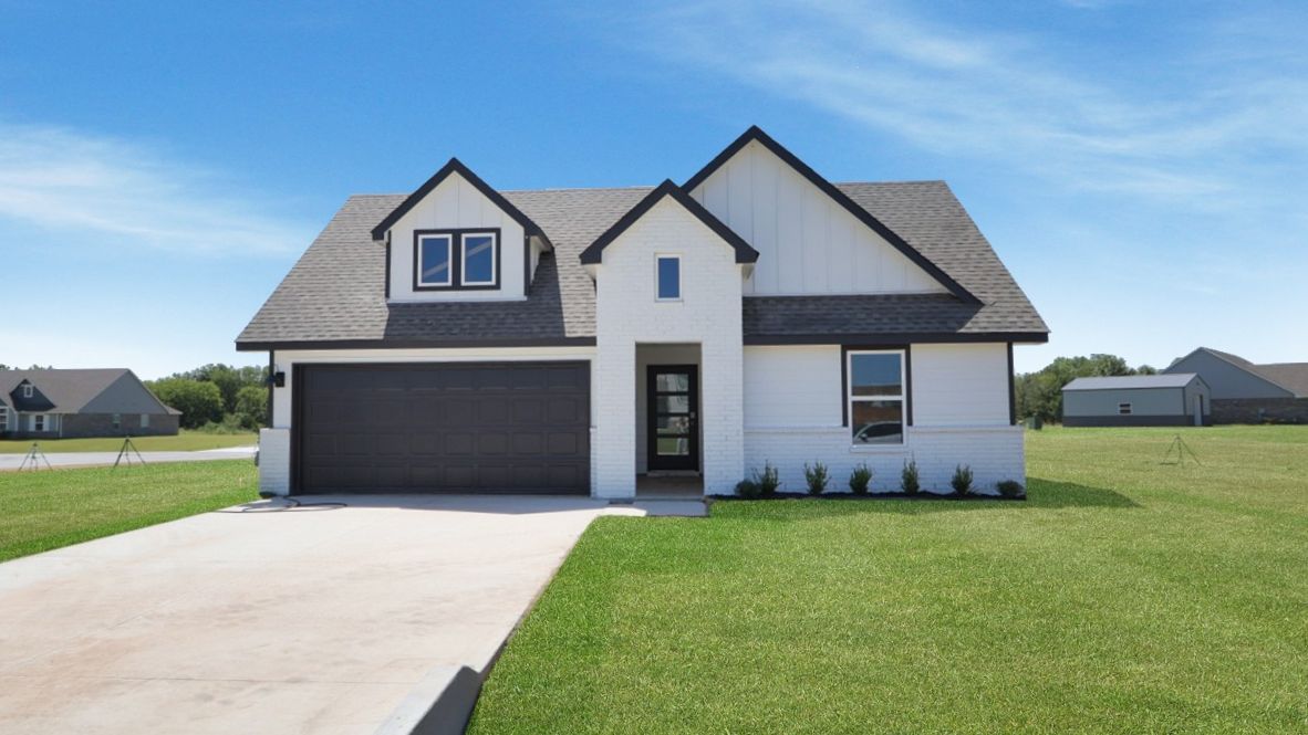 Sidewalk view showing dark garage door, white exterior, and front landscaping