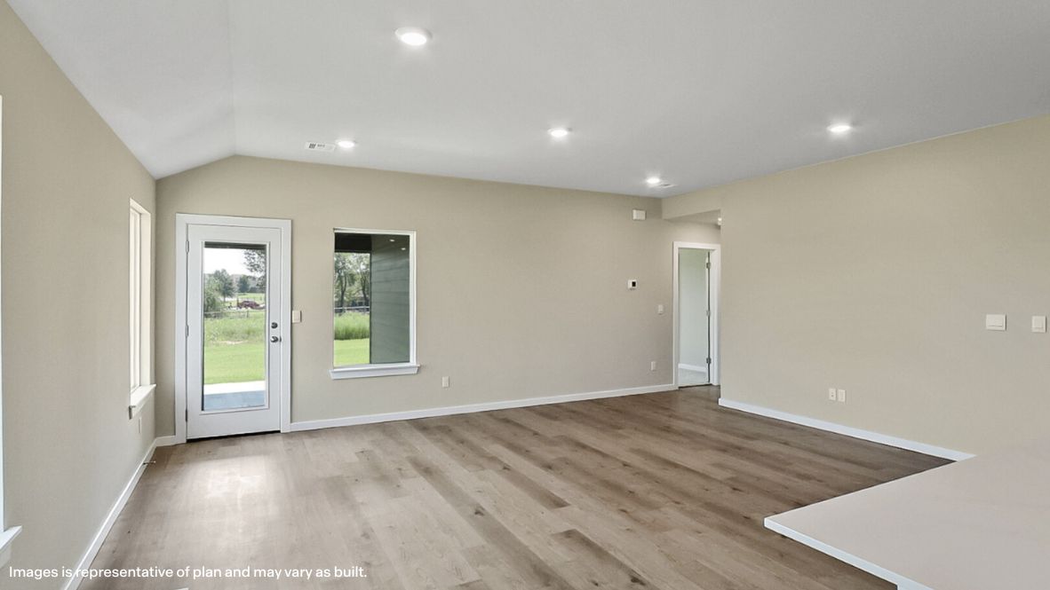 Living room view back to dining area, front hall, and front door with open concept flow