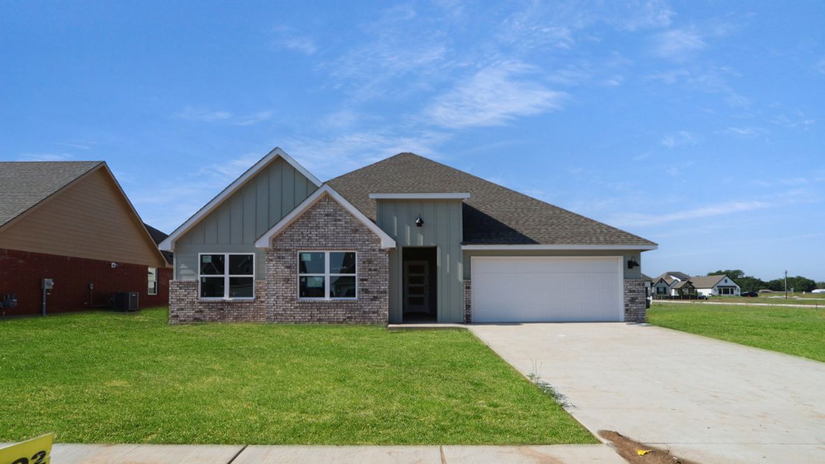 Driveway-level exterior view showing garage, entry, and front yard Rowan Grove