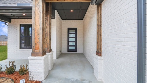 Modern single-story home with a brick exterior, two-car garage, and well-maintained front lawn in a suburban neighborhood.