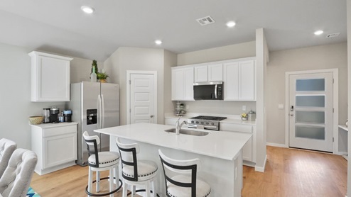 Interior of kitchen with central island next to front door