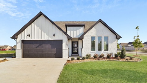 Exterior of one story home with two car garage and wood cladding