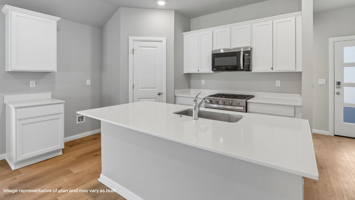Bright and spacious kitchen with quartz countertops, stainless steel appliances, and an island with bar seating.