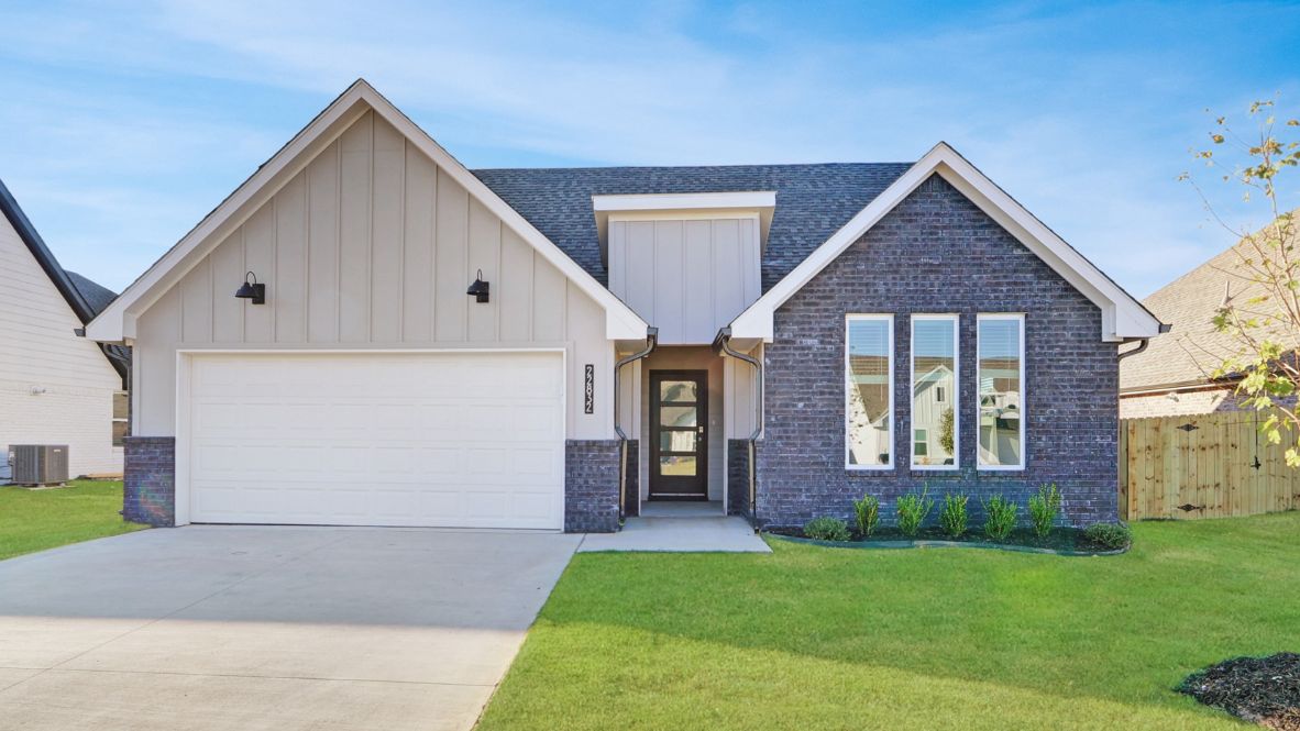 Modern single-story home with a brick exterior, two-car garage, and well-maintained front lawn in a suburban neighborhood.
